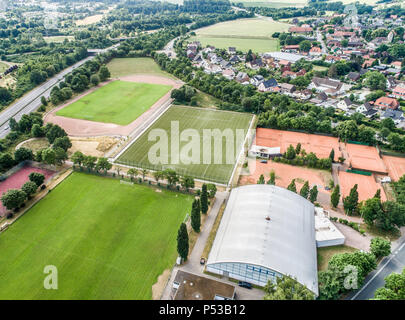 Court de tennis et de tennis intérieurs sur le bord d'un village de banlieue à côté de champs et prairies à proximité d'une autoroute Banque D'Images