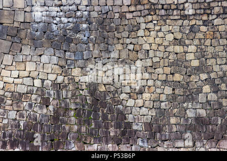 La texture de vieux mur de pierre empilés le long de l'herbe a rock. Banque D'Images