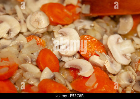 Champignons Champignons à l'oignon et les carottes sont cuites dans une poêle. Banque D'Images