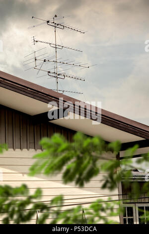 Close up classique à l'antenne TV sur toit de maison sur ciel nuageux Banque D'Images