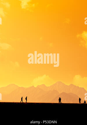 Les gens qui se profile en relaxant sur le port d'Antalya et de hautes montagnes de ciel coucher de soleil Banque D'Images