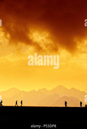 Les gens qui se profile en relaxant sur le port d'Antalya et de hautes montagnes de ciel coucher de soleil Banque D'Images