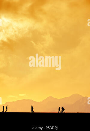 Les gens qui se profile en relaxant sur le port d'Antalya et de hautes montagnes de ciel coucher de soleil Banque D'Images