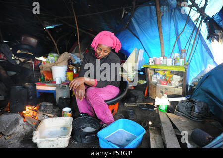 19 février 2015 - Calais, France : Portrait de Sally, un migrant illégal d'Érythrée à essayer de la Grande-Bretagne. La femme âgée de 29 ans a vécu pendant cinq mois dans ce camp 'jungle' avec son mari. Elle est enceinte de trois mois. Elle est photographiée sous la bâche qui protège sa tente et coin cuisine. Elle a voyagé à travers le Soudan, la Libye et l'Italie avant d'arriver à Calais. Des centaines d'autres migrants vivent dans des tentes dans une zone industrielle de Calais pendant qu'ils attendent pour l'occasion d'apprendre à la Grande-Bretagne. Les migrants, qui proviennent principalement de l'Érythrée, l'Éthiopie, l'Afghanistan, la Syrie, et Banque D'Images