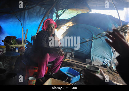 19 février 2015 - Calais, France : Portrait de Sally, un migrant illégal d'Érythrée à essayer de la Grande-Bretagne. La femme âgée de 29 ans a vécu pendant cinq mois dans ce camp 'jungle' avec son mari. Elle est enceinte de trois mois. Elle est photographiée sous la bâche qui protège sa tente et coin cuisine. Elle a voyagé à travers le Soudan, la Libye et l'Italie avant d'arriver à Calais. Des centaines d'autres migrants vivent dans des tentes dans une zone industrielle de Calais pendant qu'ils attendent pour l'occasion d'apprendre à la Grande-Bretagne. Les migrants, qui proviennent principalement de l'Érythrée, l'Éthiopie, l'Afghanistan, la Syrie, et Banque D'Images