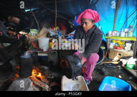 19 février 2015 - Calais, France : Portrait de Sally, un migrant illégal d'Érythrée à essayer de la Grande-Bretagne. La femme âgée de 29 ans a vécu pendant cinq mois dans ce camp 'jungle' avec son mari. Elle est enceinte de trois mois. Elle est photographiée sous la bâche qui protège sa tente et coin cuisine. Elle a voyagé à travers le Soudan, la Libye et l'Italie avant d'arriver à Calais. Des centaines d'autres migrants vivent dans des tentes dans une zone industrielle de Calais pendant qu'ils attendent pour l'occasion d'apprendre à la Grande-Bretagne. Les migrants, qui proviennent principalement de l'Érythrée, l'Éthiopie, l'Afghanistan, la Syrie, et Banque D'Images