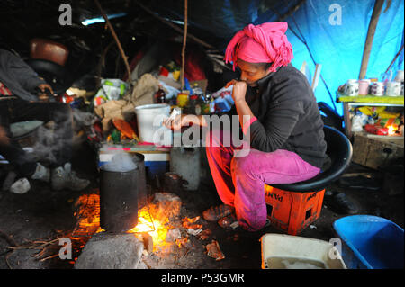 19 février 2015 - Calais, France : Portrait de Sally, un migrant illégal d'Érythrée à essayer de la Grande-Bretagne. La femme âgée de 29 ans a vécu pendant cinq mois dans ce camp 'jungle' avec son mari. Elle est enceinte de trois mois. Elle est photographiée sous la bâche qui protège sa tente et coin cuisine. Elle a voyagé à travers le Soudan, la Libye et l'Italie avant d'arriver à Calais. Des centaines d'autres migrants vivent dans des tentes dans une zone industrielle de Calais pendant qu'ils attendent pour l'occasion d'apprendre à la Grande-Bretagne. Les migrants, qui proviennent principalement de l'Érythrée, l'Éthiopie, l'Afghanistan, la Syrie, et Banque D'Images