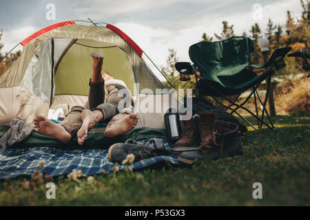 Jeune couple romantique située à l'intérieur d'une tente de camping. L'homme et de la femme dans l'amour dans une tente. Banque D'Images