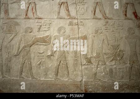 L'Égypte. Saqqara. Mastaba de Ptahhotep et Akhethotep. 5ème dynastie. Vieux Royaume. Vizirs égyptiens. Père et fils. Relief représentant polychrome offrant des porteurs. Banque D'Images