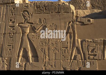 L'art égyptien Le Temple de Karnak complexe. Relief représentant le pharaon Ramsès II Faire une offrande à un dieu égyptien. 19e dynastie. Nouveau Royaume. L'Égypte. Banque D'Images