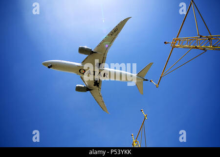 Un avion de Qatar Airways vole au-dessus de l'éclairage d'approche des pylônes électriques à mesure qu'il arrive d'atterrir à l'aéroport d'Édimbourg Banque D'Images