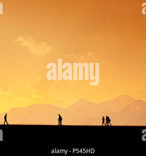 Les gens qui se profile en relaxant sur le port d'Antalya et de hautes montagnes de ciel coucher de soleil Banque D'Images