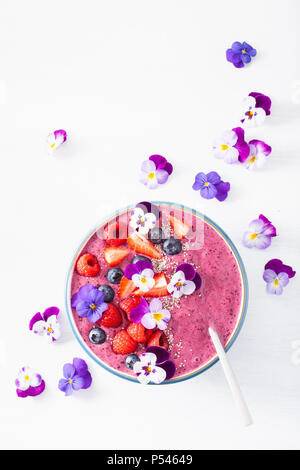 Smoothie d'été saine berry bowl avec fleurs et semences chia Banque D'Images