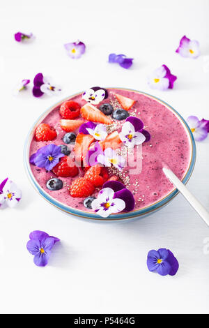 Smoothie d'été saine berry bowl avec fleurs et semences chia Banque D'Images