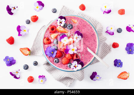 Smoothie d'été saine berry bowl avec fleurs et semences chia Banque D'Images