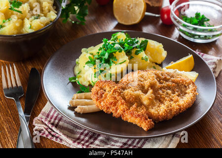 Escalopes viennoises panées avec pommes de terre au four et de la salade. Une cuisine européenne Banque D'Images