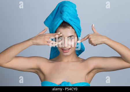 Belle femme avec des serviettes sur la tête l'application après la douche crème Banque D'Images
