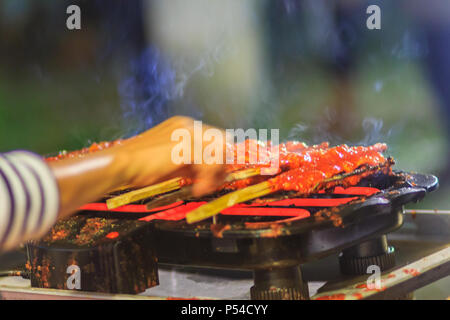 Close up vendeur au cours de la cuisson du poulet épicé du Sud. 'Kor Lae' poulet grillé est populaire dans Nakhon Sri Thammarat, sud de la Thaïlande qui peu Banque D'Images