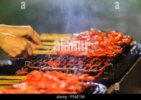 Close up vendeur au cours de la cuisson du poulet épicé du Sud. 'Kor Lae' poulet grillé est populaire dans Nakhon Sri Thammarat, sud de la Thaïlande qui peu Banque D'Images