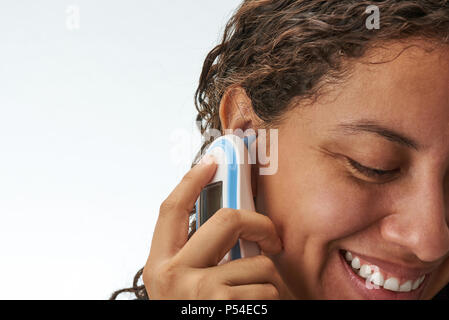 Mesurer corps tempetrature dans l'oreille de jeune femme isolée sur fond blanc Banque D'Images