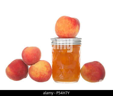 Un pot de confiture de pêches en conserve fraîchement isolé sur fond blanc avec des pêches mûres autour du pot. Fruits d'été. Banque D'Images