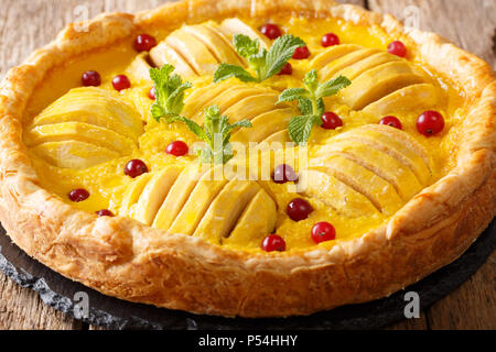 Ouvrez tarte aux canneberges et crème anglaise est décoré à la menthe close-up sur la table horizontale. Banque D'Images