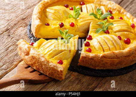 Morceau de gâteau pommes canneberges et délicieux avec de la crème anglaise sur la table horizontale. Banque D'Images