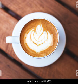 Une tasse de café avec latte art sur table en bois. Vue de dessus, l'humeur du matin, cappuccino italien. Banque D'Images