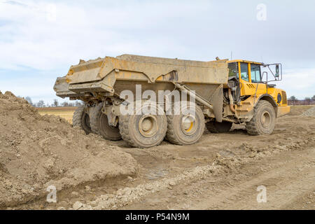 Les camions à benne à un site de construction loameux Banque D'Images