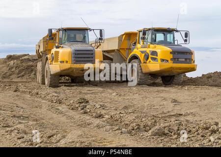 Les camions à benne à un site de construction loameux Banque D'Images