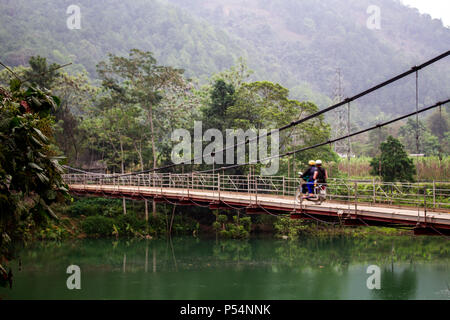 Ha Giang, Vietnam - Mars 17, 2017 : les gens sur une moto pour traverser un petit pont sur une rivière dans la région la plus au nord du Vietnam Banque D'Images