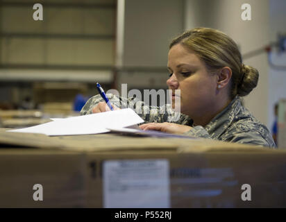 U.S. Air Force Tech. Le Sgt. Holli Woods, chef de section avec le 379e Escadron de soutien de la Force expéditionnaire du Canada, vérifie les numéros de manifeste d'expédition contre l'envoi reçu à Al Udeid Air Base, Qatar 10 mai 2017. Chaque semaine, une petite équipe d'aviateurs canadiens travaillent ensemble pour examiner les expéditions de produire, en s'assurant que le nombre correspond à la quantité reçue et que la qualité du produit répond aux normes. Banque D'Images