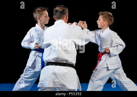 La formation d'un instructeur de karaté mâles petits enfants en dojo Banque D'Images