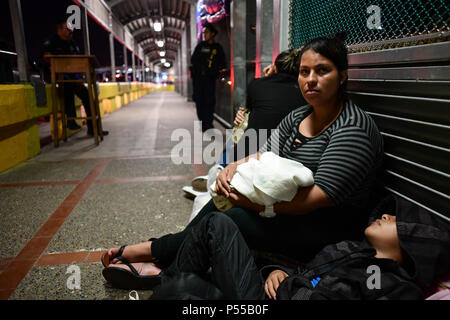 Brownsville, Texas, USA. 24 Juin, 2018. Cristina, 27 ans, femme du Honduras, ses deux mois bébé Naomi et todler Manuel, arrivée le dimanche soir au pont reliant Matamoros, Mexique à Brownsville, Texas, la dernière partie d'un parcours qui a commencé il y a deux mois à San Pedro Sula, au Honduras. Comme l'administration d'Atout brouillées pour faire face à une crise de l'immigration à la frontière, un flux continu de migrants arrivent chaque jour. Credit : Miguel Juarez Lugo/ZUMA/Alamy Fil Live News Banque D'Images