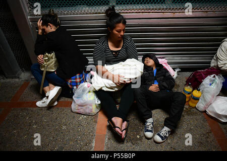 Brownsville, Texas, USA. 24 Juin, 2018. Cristina, 27 ans, femme du Honduras, ses deux mois bébé Naomi et todler Manuel, arrivée le dimanche soir au pont reliant Matamoros, Mexique à Brownsville, Texas, la dernière partie d'un parcours qui a commencé il y a deux mois à San Pedro Sula, au Honduras. Comme l'administration d'Atout brouillées pour faire face à une crise de l'immigration à la frontière, un flux continu de migrants arrivent chaque jour. Credit : Miguel Juarez Lugo/ZUMA/Alamy Fil Live News Banque D'Images
