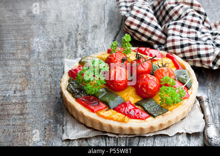 Quiche végétarienne colorée avec le poivre et les tomates cerise sur table en bois Banque D'Images