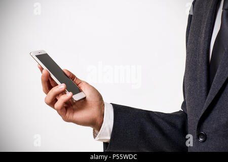 Hand holding white Smartphone avec écran blanc sur fond gris. Banque D'Images