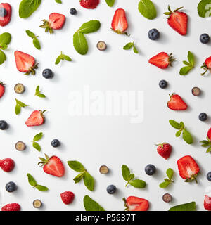 Modèle des fruits de châssis avec les fraises, les bleuets et les feuilles de menthe sur un fond blanc, télévision lay Banque D'Images