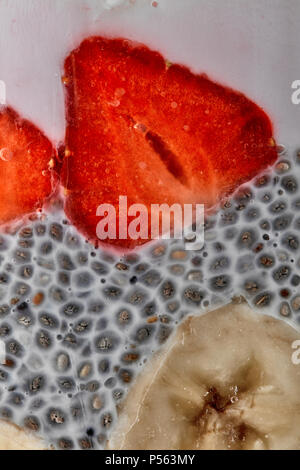 Les graines de chia pudding aux fraises et bananes purée dans un bocal en verre, macro shot Banque D'Images