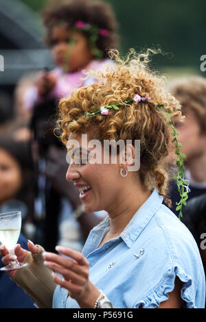 Image candide d'une jeune femme élégante avec un verre à la main à l'Afrique danse 2018 Oye music festival à Sefton Park, Liverpool. Banque D'Images