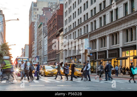 Scène de rue au rythme soutenu avec les gens de marcher à travers une intersection achalandée sur Broadway à Manhattan, New York City Banque D'Images