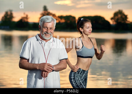 Senior et Jeune fille courir près du lac dans la soirée. Activités de plein air, mode de vie sain, fort compétents, mettre en place des chiffres. Sportswear chic et moderne. Différentes générations. Le sport, yoga, fitness. Banque D'Images