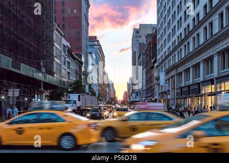 Les taxis jaunes sur Broadway accélération durant les heures de pointe à Manhattan, New York City avec ciel coucher de soleil colorés en arrière-plan Banque D'Images