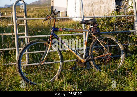 Vieux vélo rouillé calé contre une clôture, Valentia Island dans le comté de Kerry, Irlande Banque D'Images