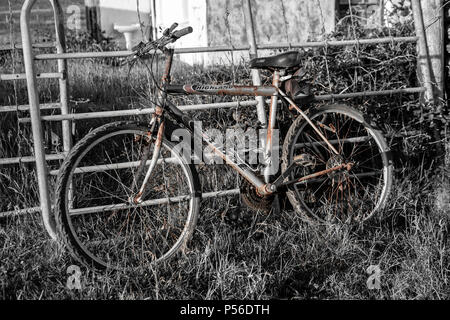 Vieux vélo rouillé calé contre une clôture, Valentia Island dans le comté de Kerry, Irlande Banque D'Images