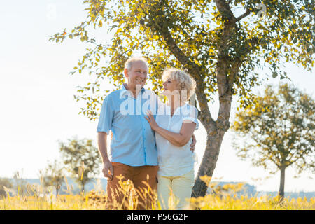 Romantic senior couple holding hands en marchant ensemble dans la campagne Banque D'Images