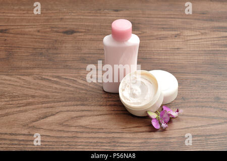 Une baignoire de la lotion pour les afficher avec une petite bouteille de lotion rose avec une petite fleur pourpre Banque D'Images