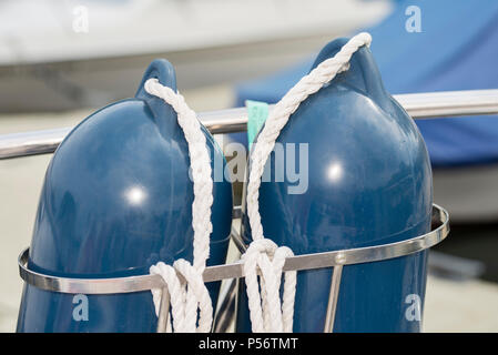 Deux bleu bateau dans une demi aile blanc portrait avec des cordes dans une fixation sur un bateau garde-fous Banque D'Images