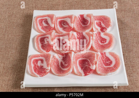 Porc frais entrelardées dans un plat blanc Banque D'Images