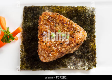 Balle de riz japonais onigiri sur fond de bois. Banque D'Images